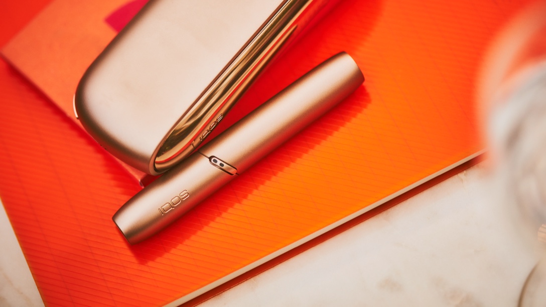 An IQOS 3 DUO and Holder in a person's hands.