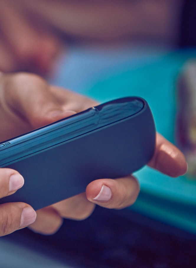 Woman holding her grey IQOS